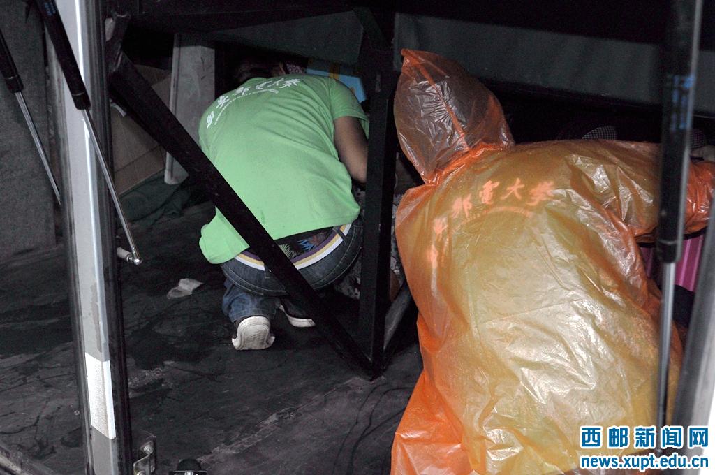 志愿者们钻到狭小的行李舱整理行李,感动